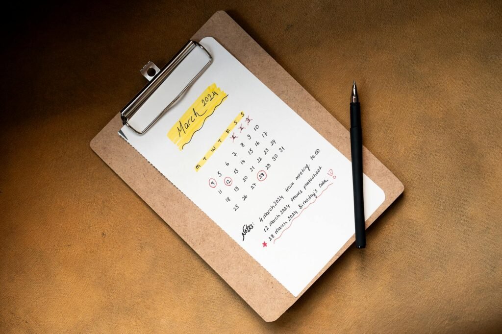 Notebook and calendar on a desk for a monthly money reset