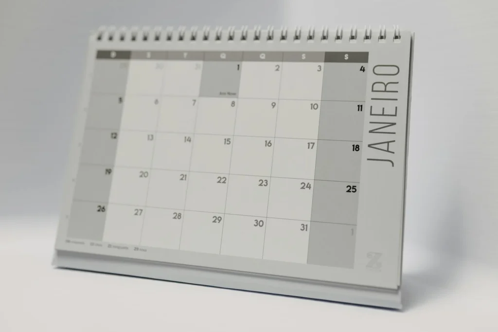 A desk calendar marked with bill due dates and paydays.