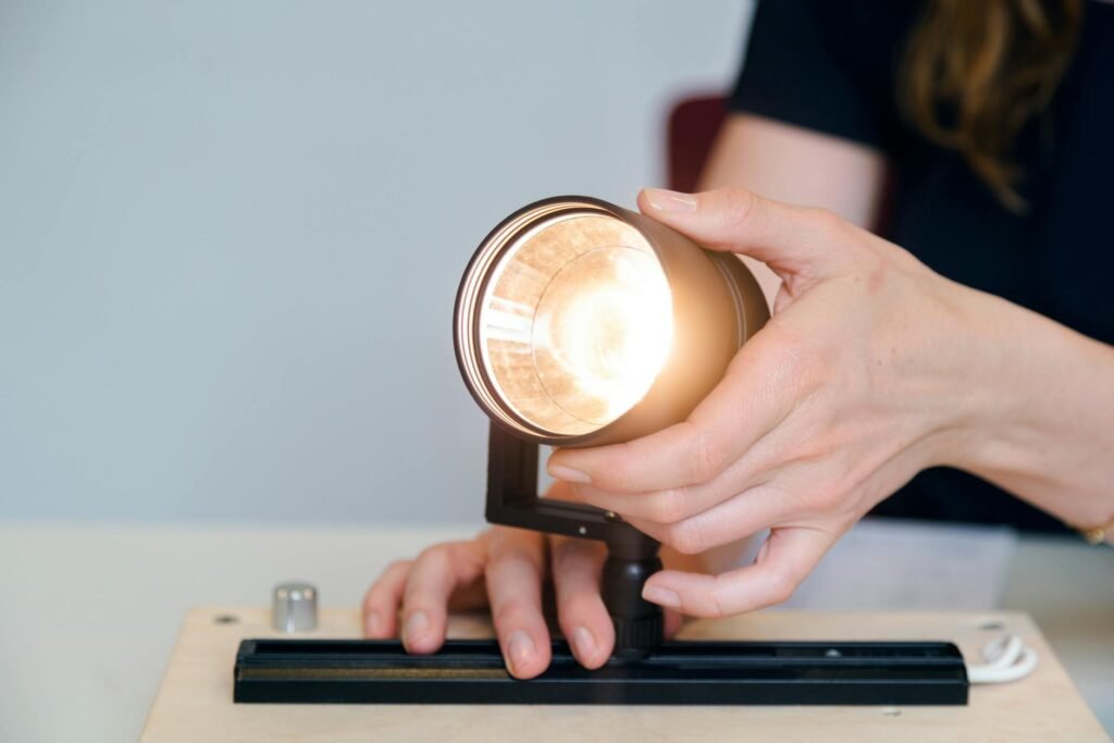 A hand installing an LED light bulb