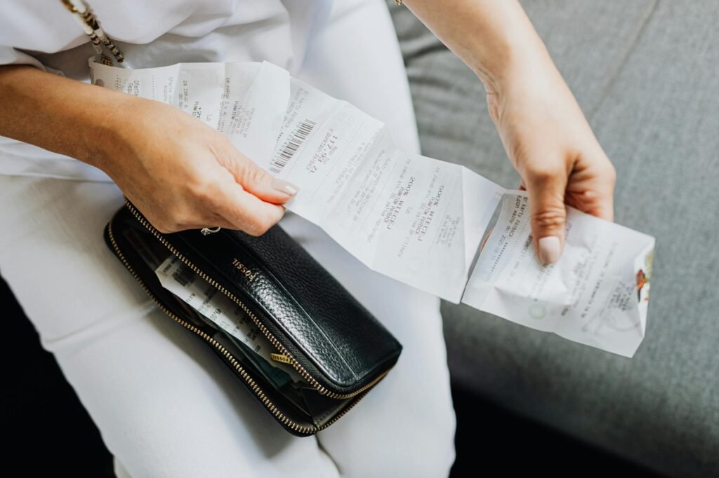 Hands reviewing receipts to track spending habits