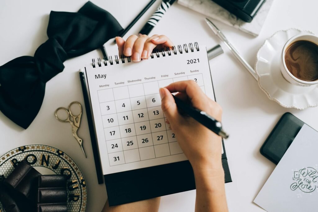 Notebook and calendar on a desk set up for a monthly money reset