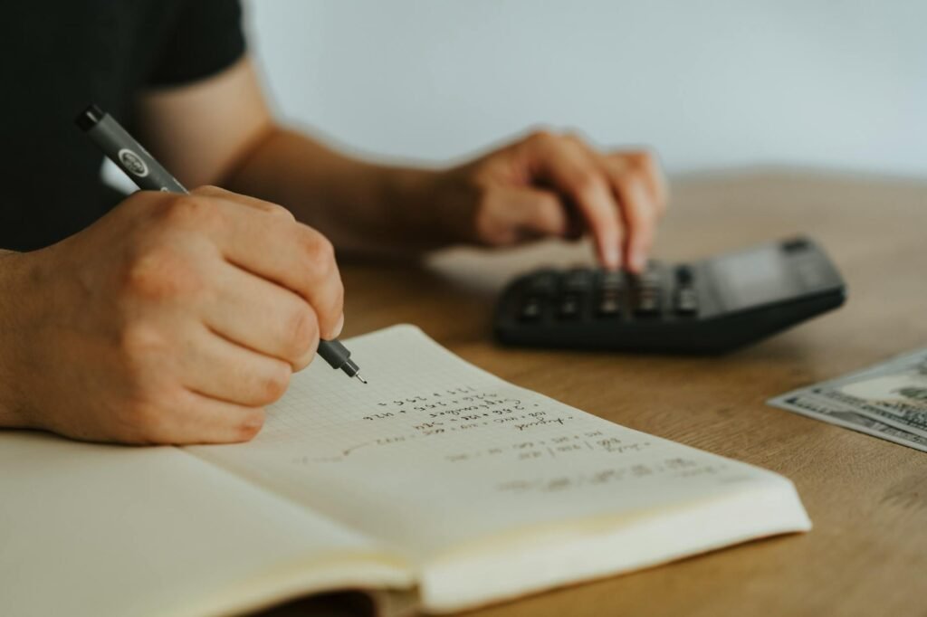 Notebook and calculator on a desk set up for a monthly budget check-in