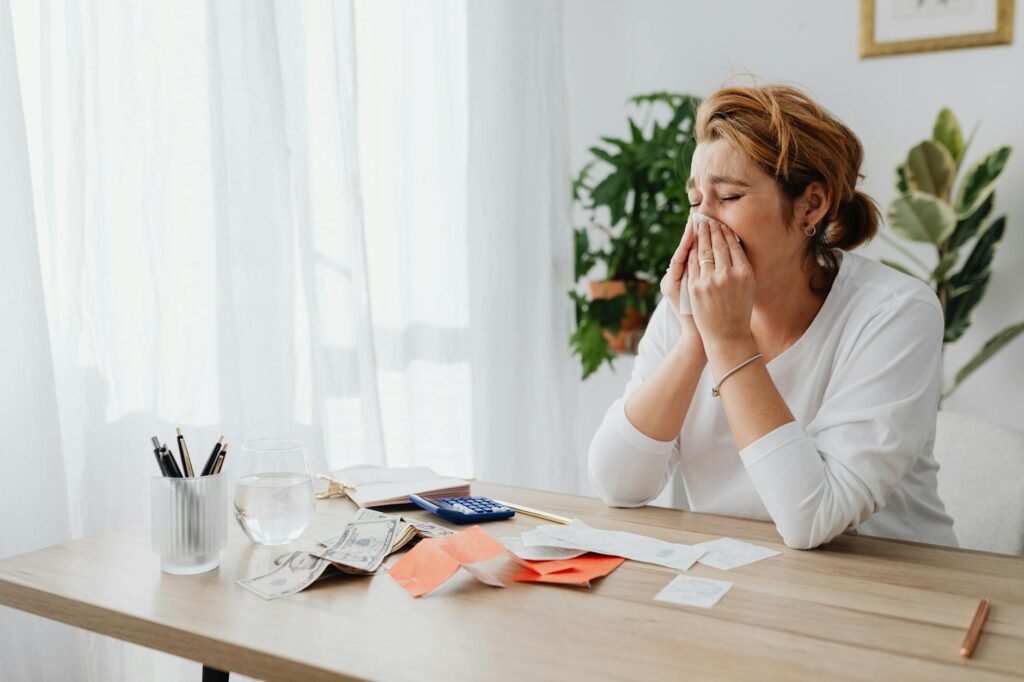 A household budgeting worksheet next to utility bills, a calculator, and a pen on a table