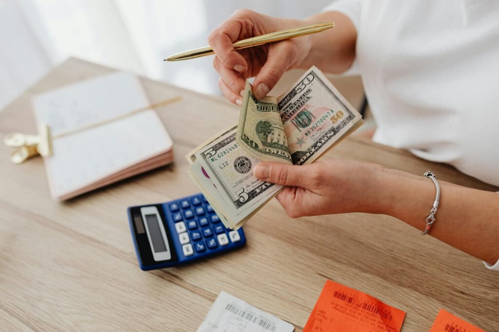 Notebook and calculator next to household bills on a desk