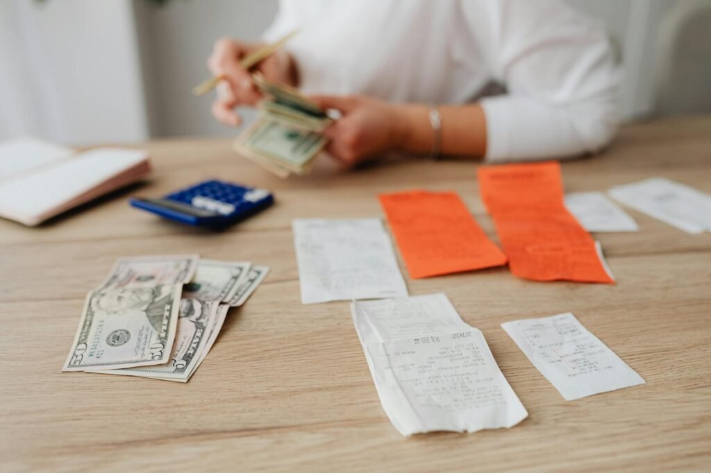 Grocery receipt, calculator, and notepad for tracking monthly spending