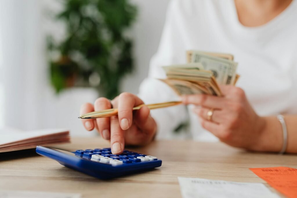 Notebook budget with monthly bills and calculator on a kitchen table