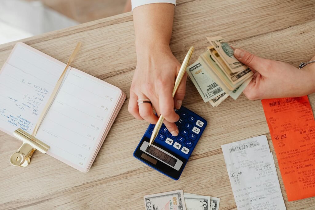 Notebook, calculator, and household bills laid out for budgeting