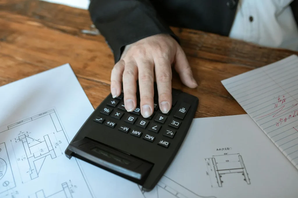 A pay stub next to a budget worksheet and calculator on a desk