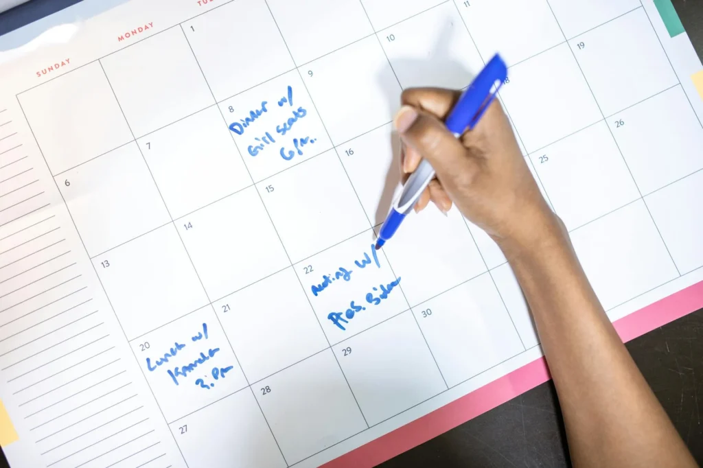 Hand crossing off bills on a checklist