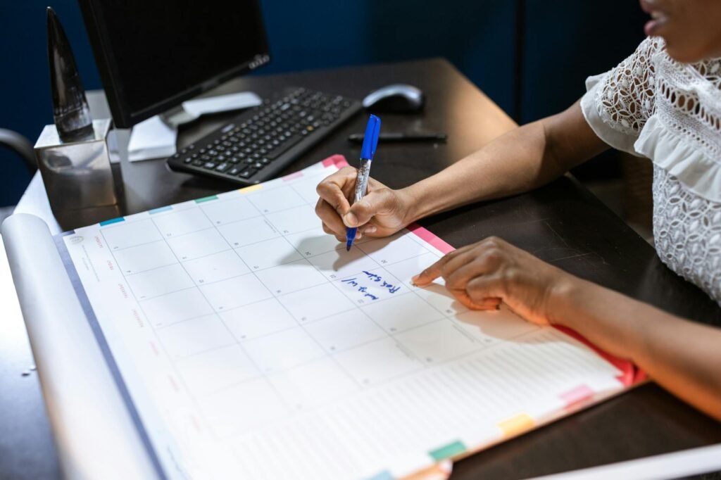 Calendar and pen used to plan bill due dates on a clean desk