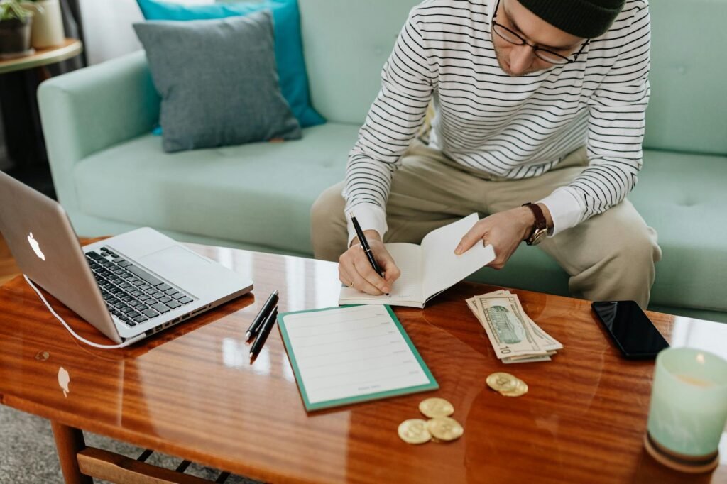 Notebook and pen next to a printed bank statement on a desk