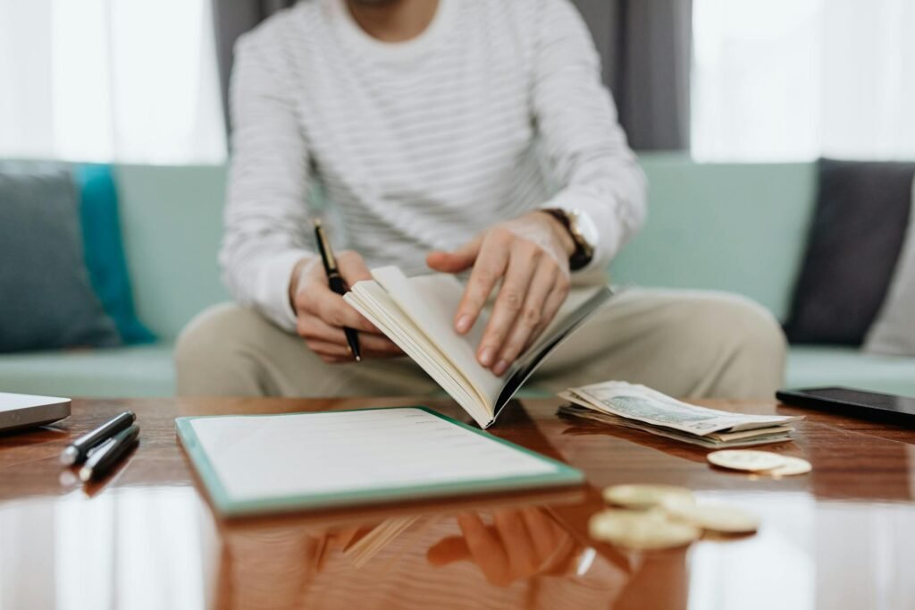 A home budgeting setup with paper statements, a calculator, and handwritten notes on a table.