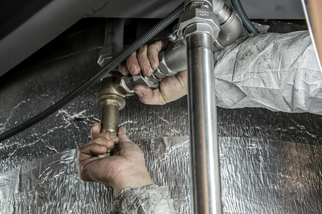 A plumber fixing a small household leak under a sink