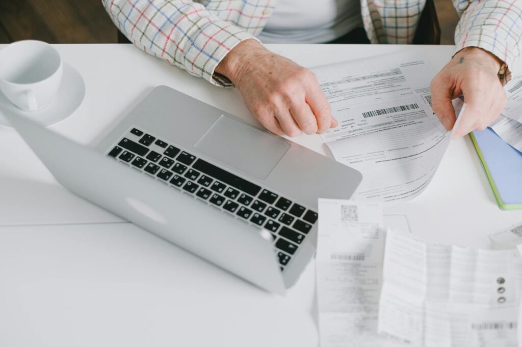 Hands sorting bills and mail on a kitchen table