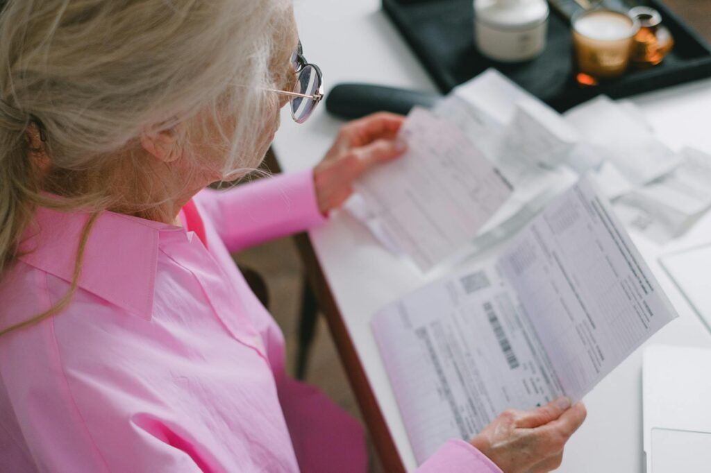 Hands reviewing bills and statements for a monthly money reset