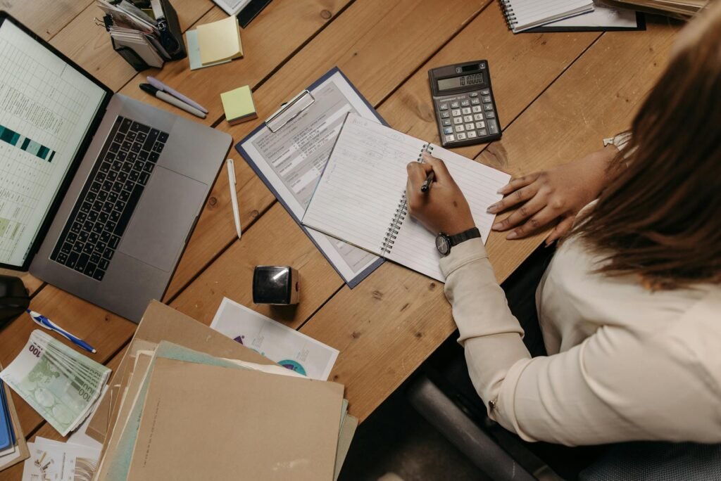 A notebook and calculator on a desk set up for budgeting