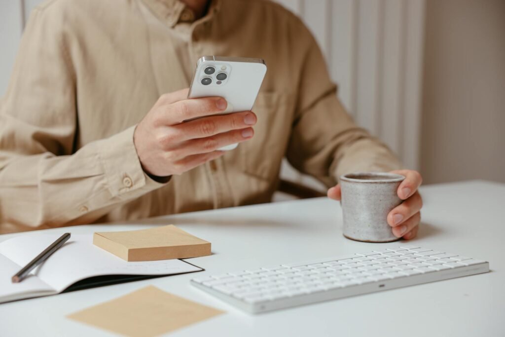 Smartphone on a desk next to a notepad