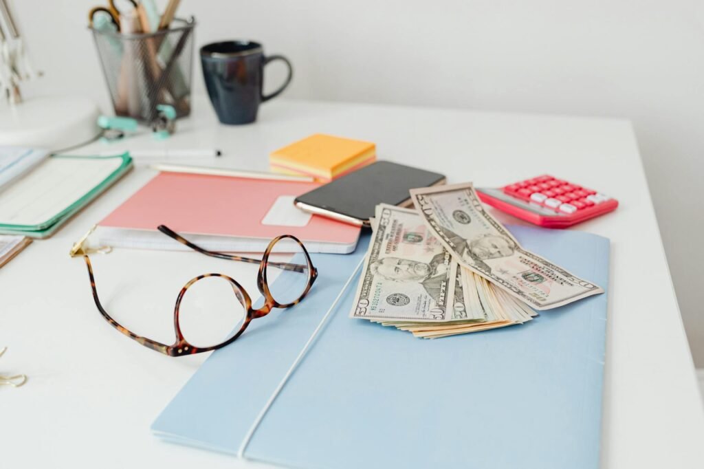 Notebook and calculator on a tidy desk with household bills ready to review