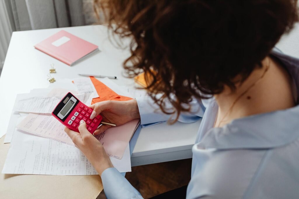 Person reviewing a monthly budget with a notebook and calculator