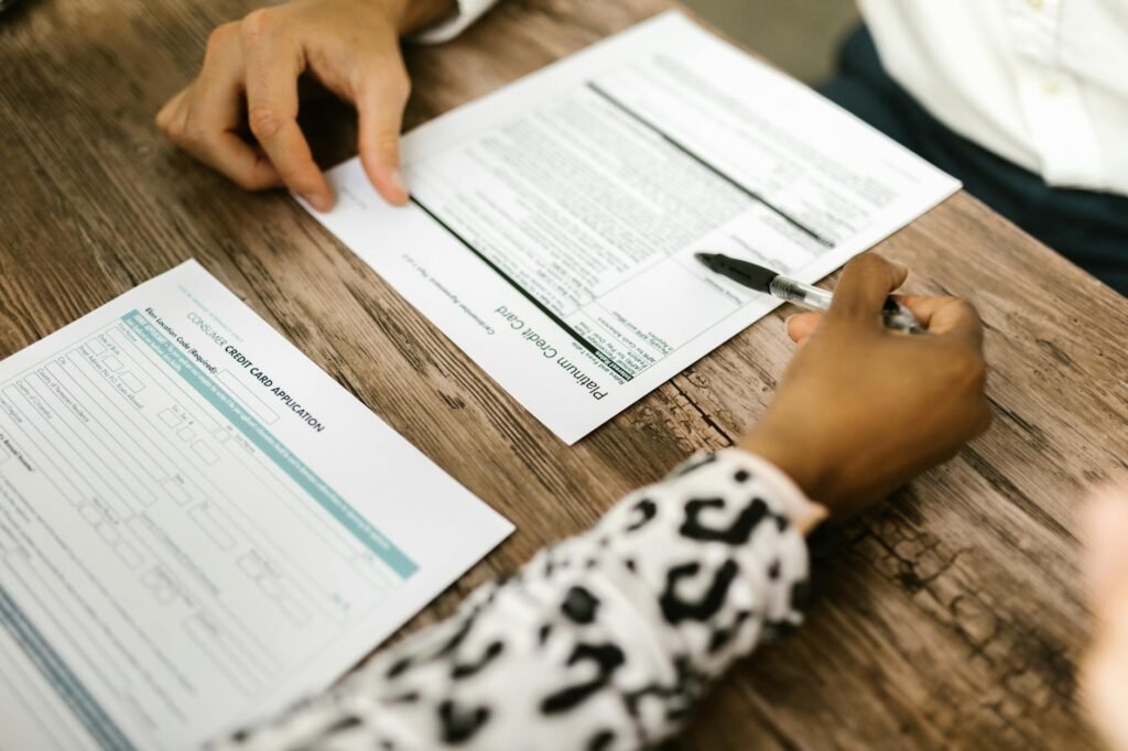 Hands reviewing a bank statement with a pen and calculator