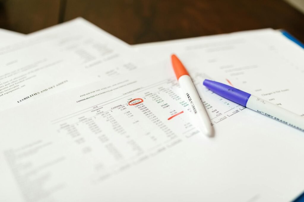 Someone reviewing receipts and bank statements with a highlighter and calculator
