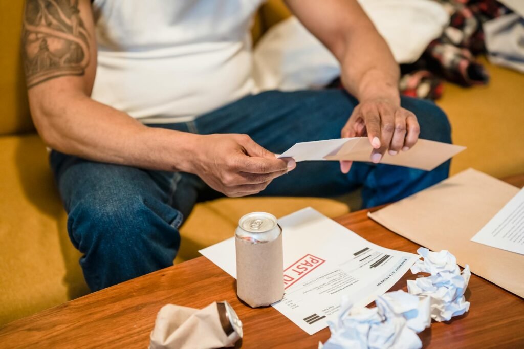 Hands organizing bills and envelopes on a table