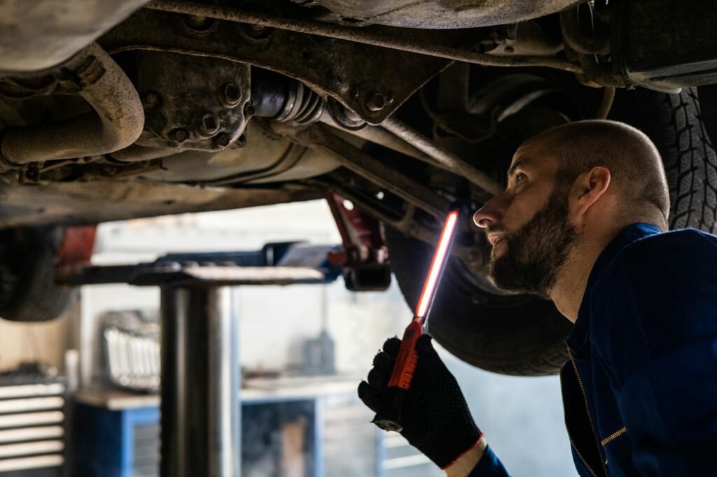 A mechanic performing a pre-purchase inspection on a used car