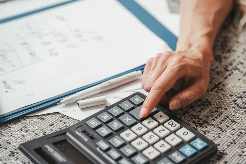 Hands reviewing a bank statement with a calculator